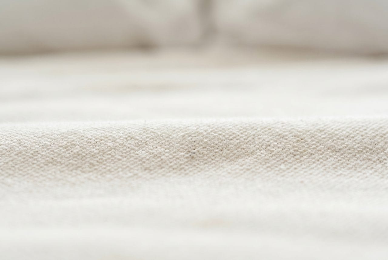 Allergen particles settled deep in mattress fabric